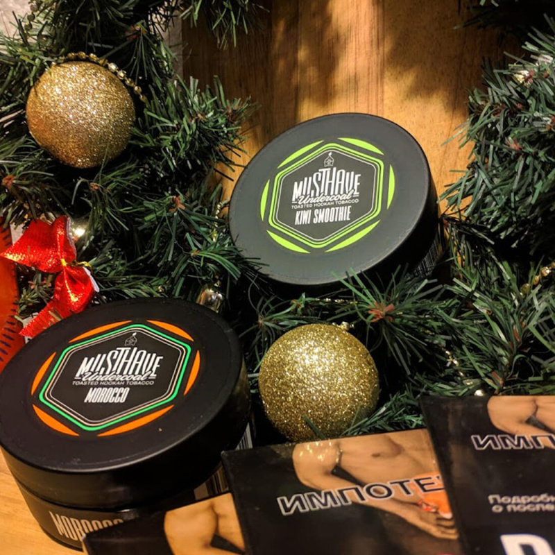 Табак для кальяна в банках разных брендов на фоне углей и щипцов